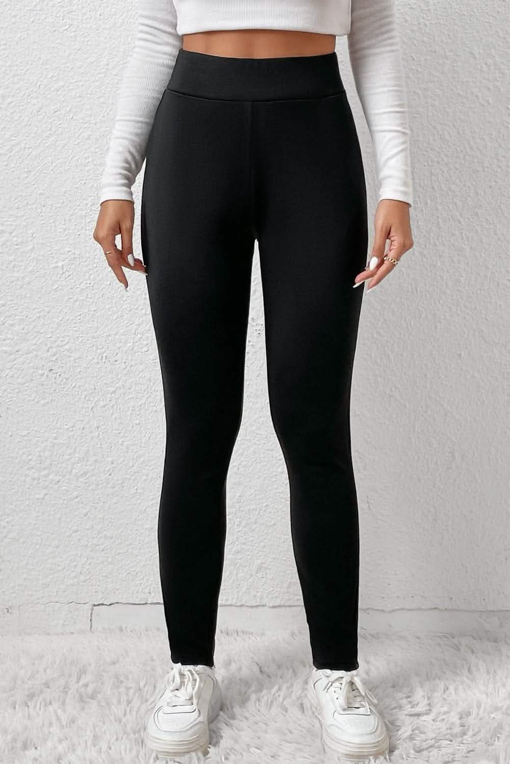 Cozy black high-waist sport leggings styled with a white long-sleeve top, shown full-length against a neutral background.