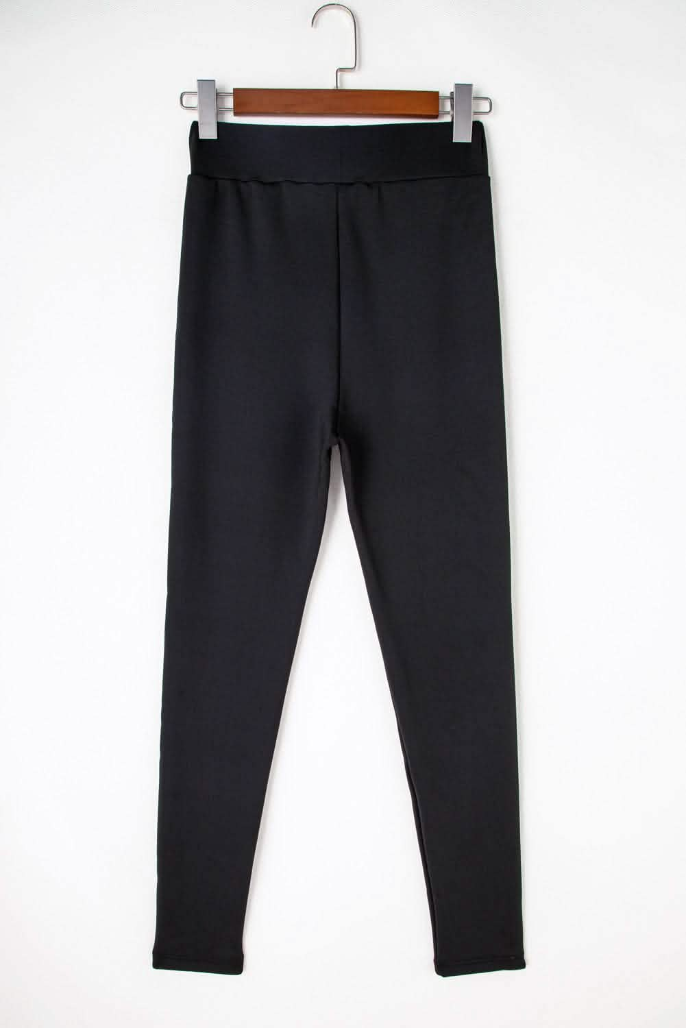 Black high-waist sport leggings displayed on a hanger against a white background, showcasing the sleek and cozy design.