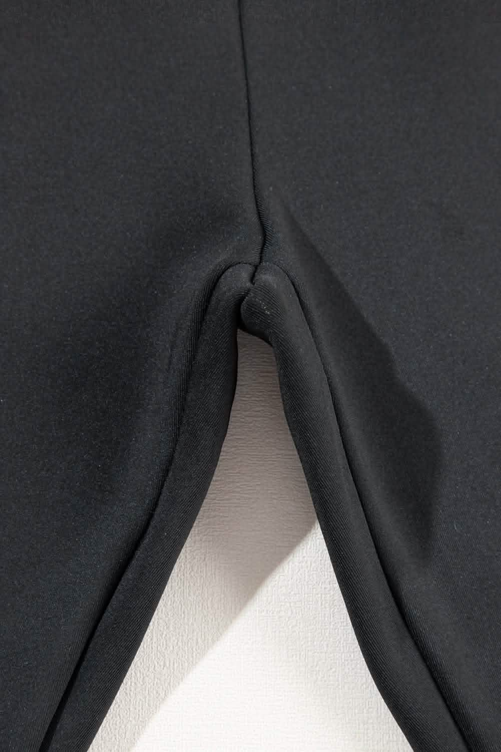 Close-up of black high-waist sport leggings showcasing the seamless stitching and smooth fabric detail.