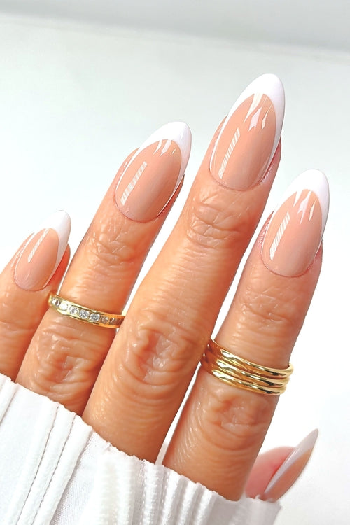 A hand with long, almond-shaped nails featuring a French manicure. The tips are white, and the base is a natural pink. 