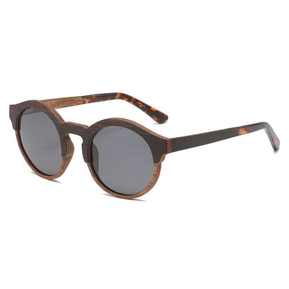 Round retro-style sunglasses with laminated wood and solid wood frame design, featuring dark lenses and tortoiseshell-patterned temples.