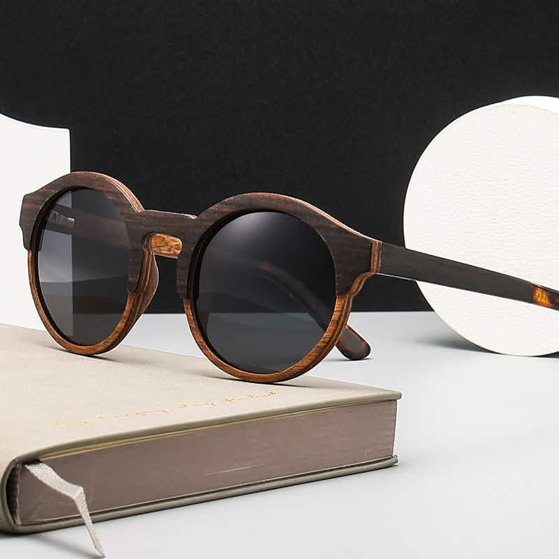 Retro round frame sunglasses with laminated wood, solid wood design, featured on a minimalist surface with book and decor.