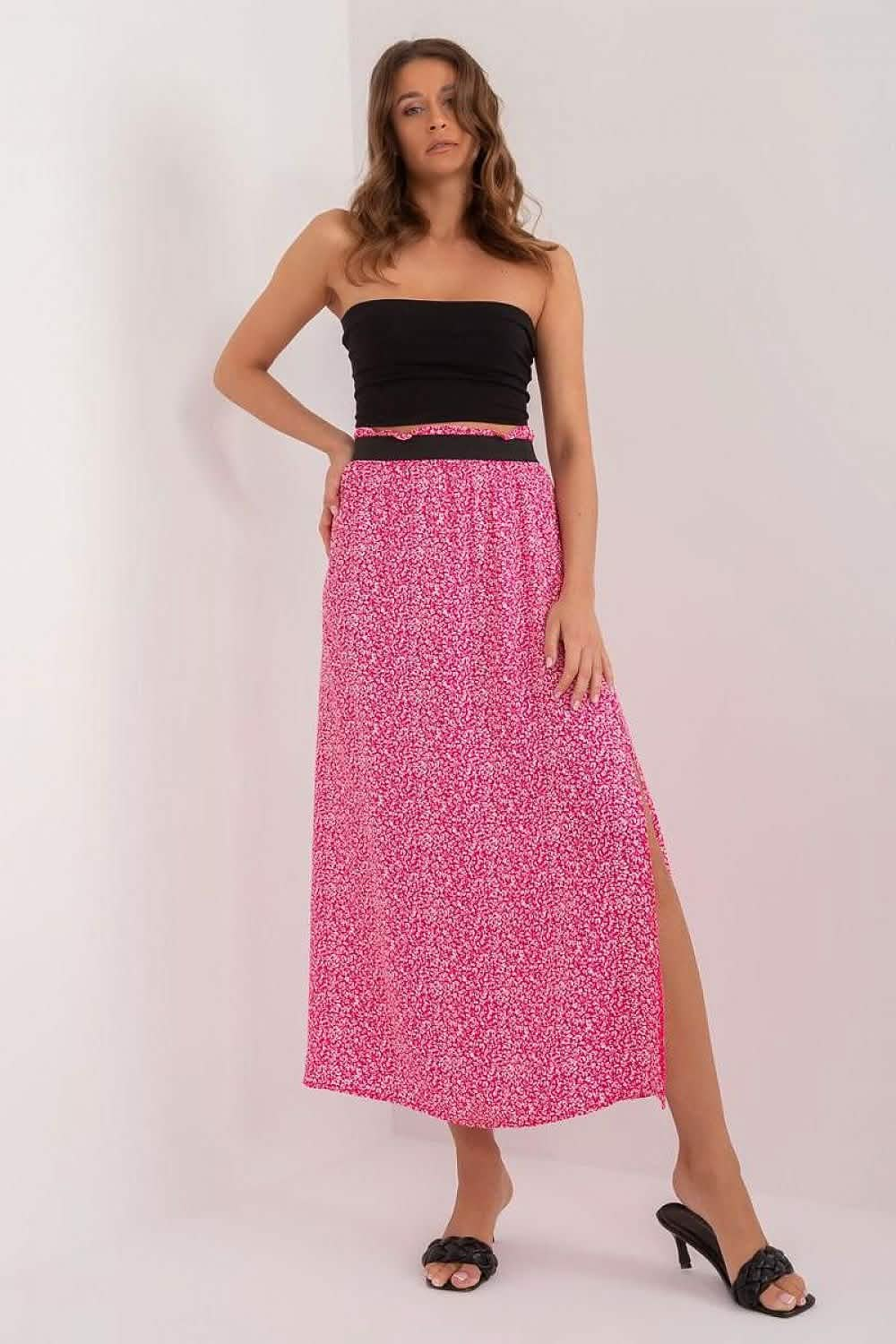 Pink floral midi skirt with a side slit paired with a black tube top.