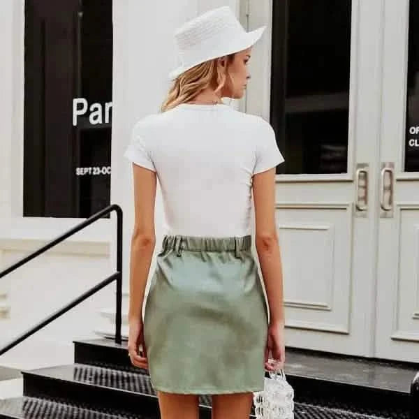 White t-shirt and sage green skirt outfit paired with a white hat.