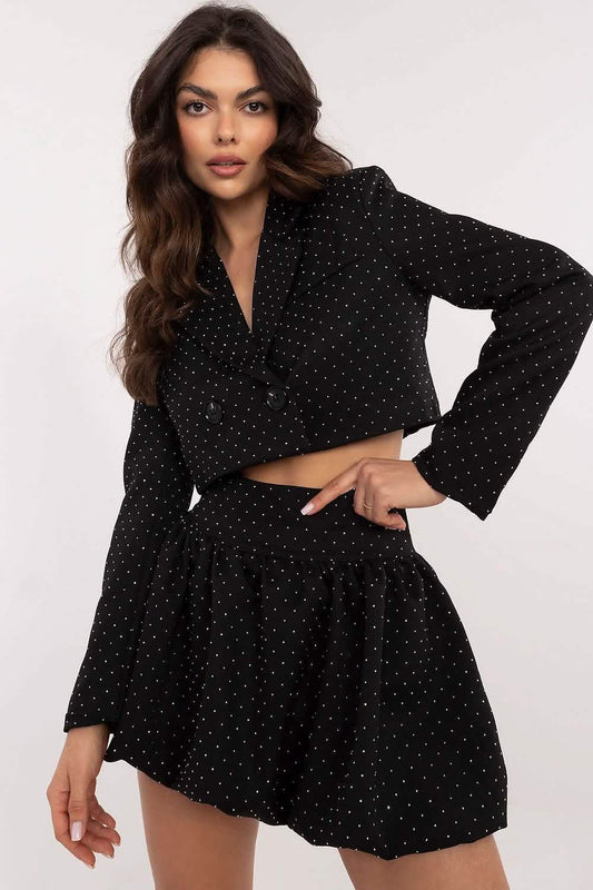 Black polka dot two-piece outfit with a cropped long-sleeve top and flared mini skirt.