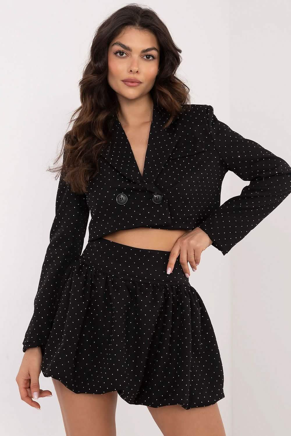 Black polka dot two-piece outfit with a cropped blazer and pleated mini skirt.