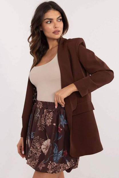 Brown oversized blazer worn with a beige tank top and floral print skirt.