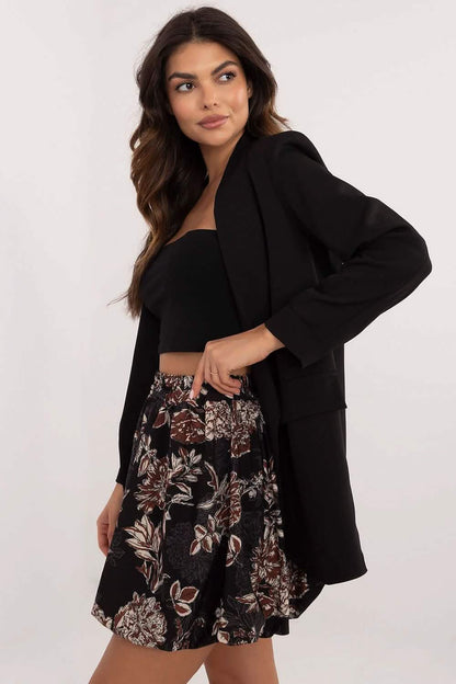 Black oversized blazer worn with a floral skirt and crop top.