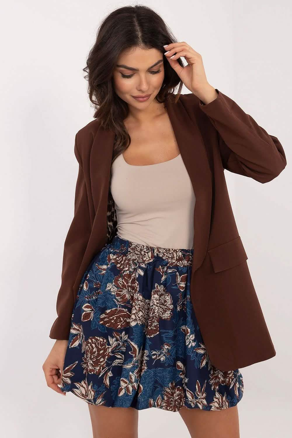 Brown blazer paired with a beige tank top and floral blue skirt.