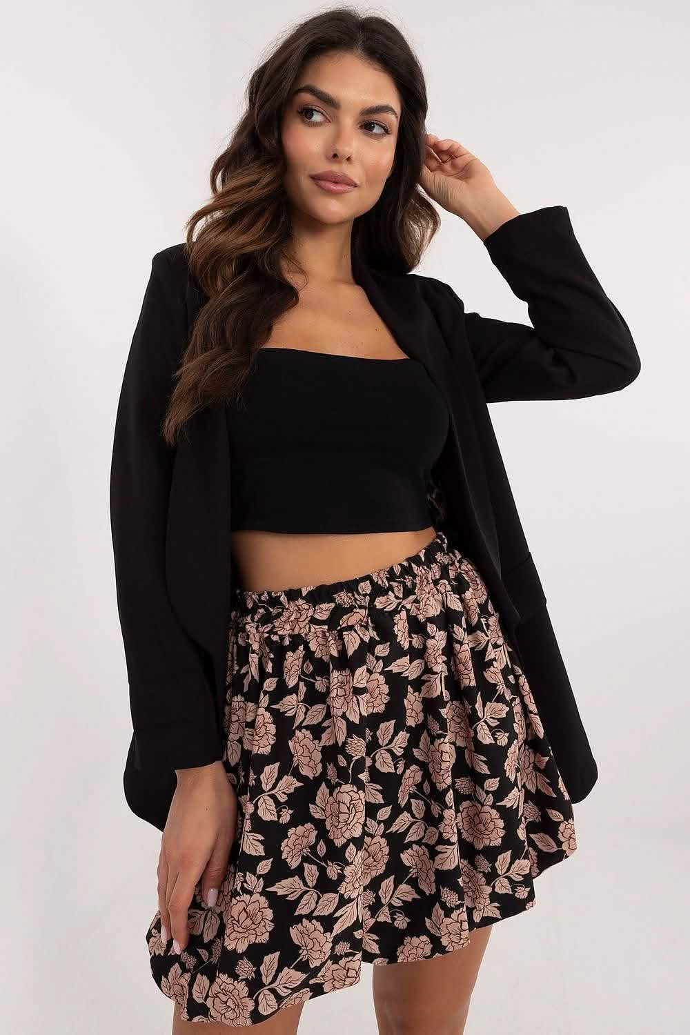 A floral print mini skirt paired with a black crop top and blazer.