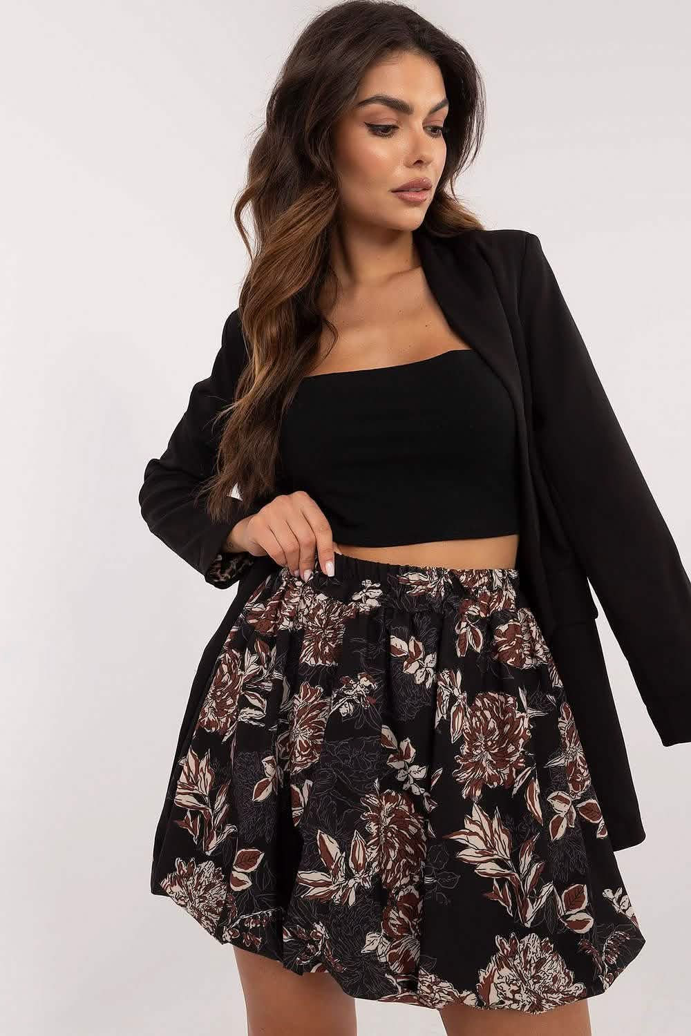 A floral print skater skirt paired with a black crop top and blazer.