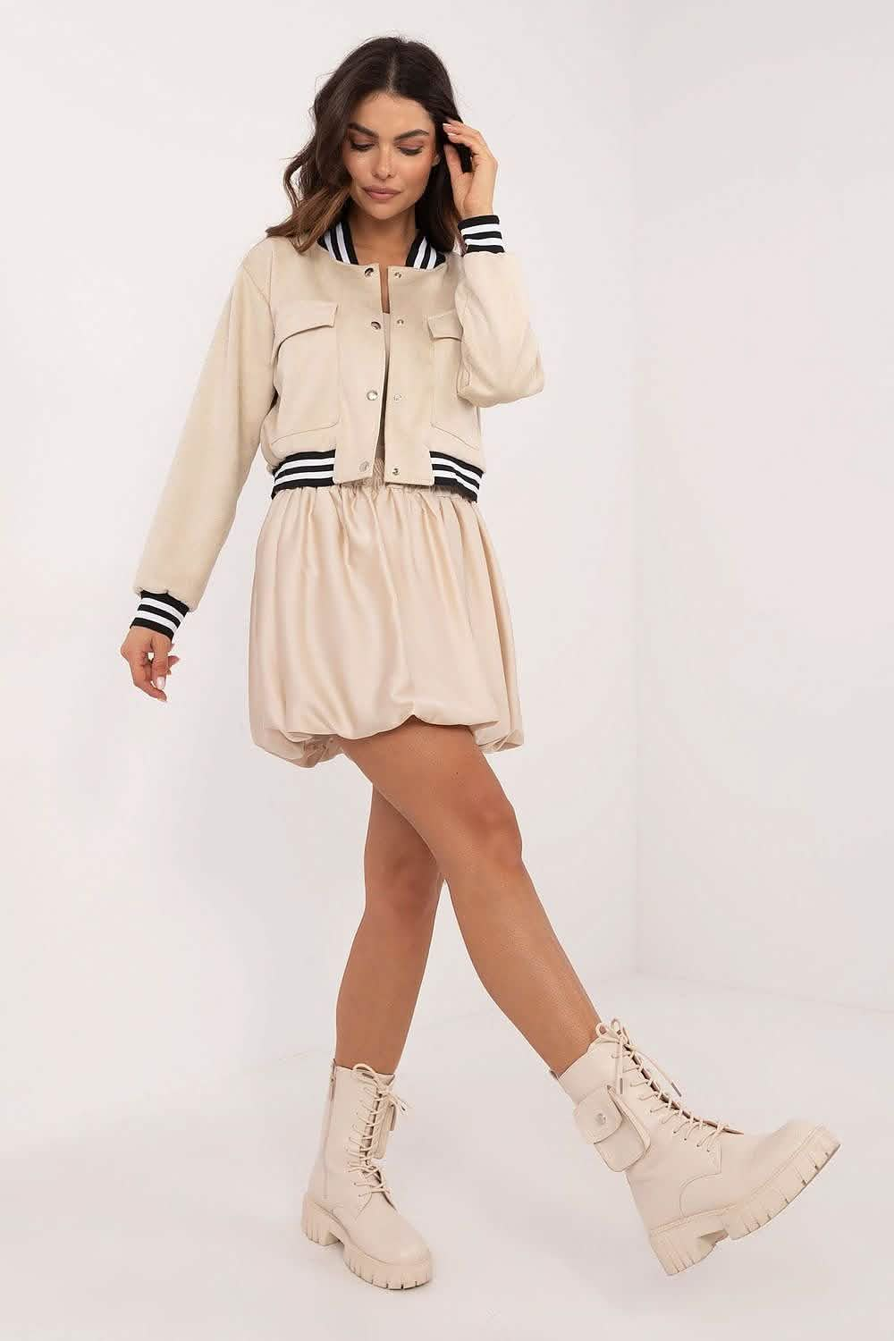 Beige bomber jacket and shorts set paired with cream combat boots.