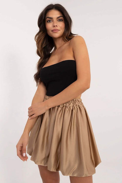 Black strapless top paired with a flowy beige mini skirt.