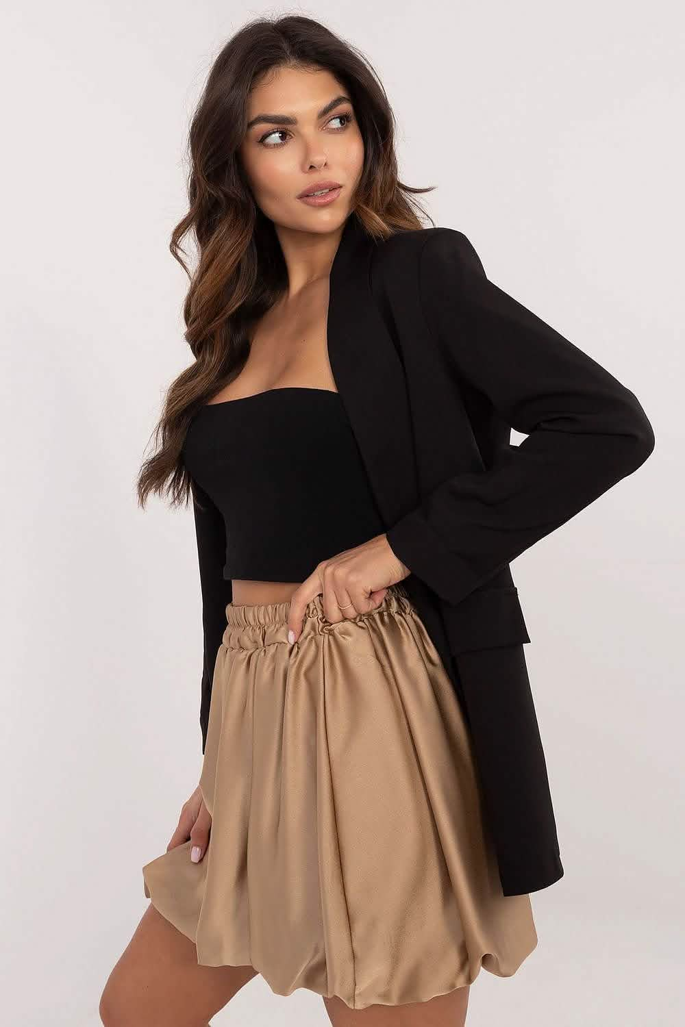 Black blazer paired with a flowy khaki-colored skirt and black crop top.