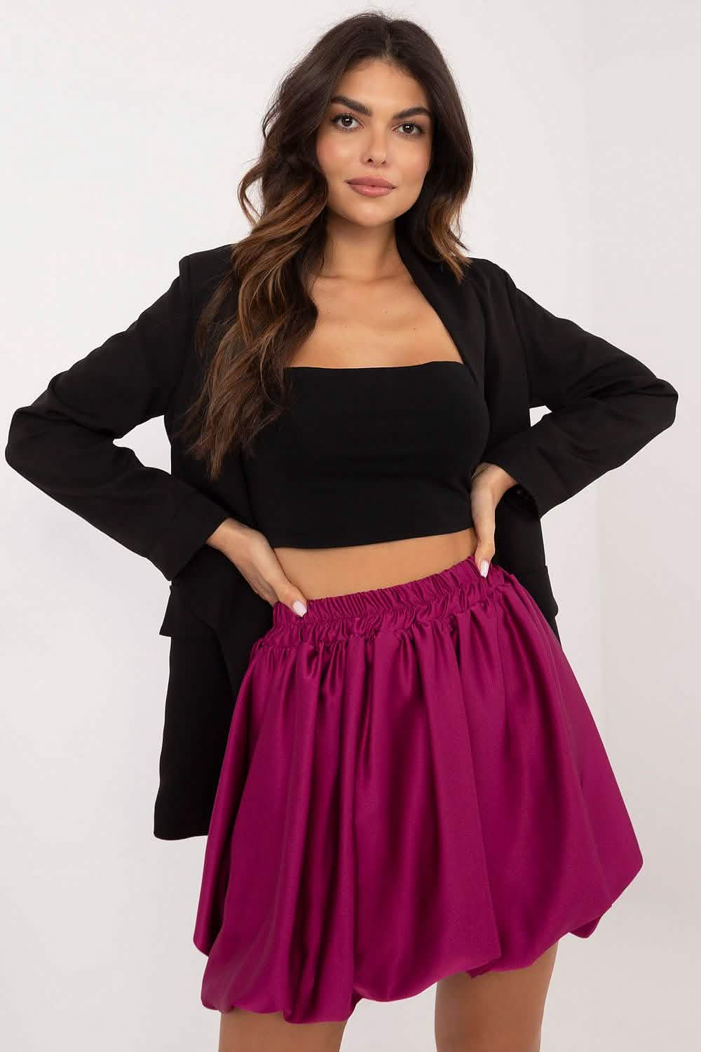 A flowy magenta skater skirt paired with a black crop top and blazer.