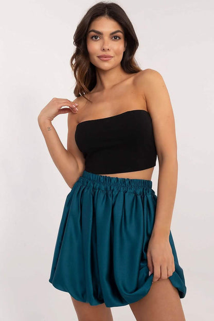 Teal flowy shorts paired with a black strapless crop top.