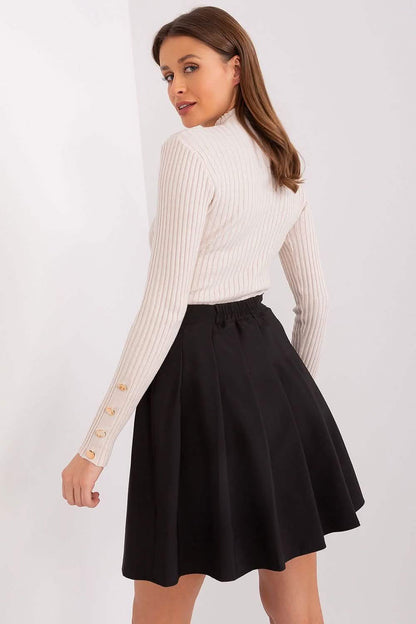 Black flared skater skirt paired with a white ribbed turtleneck sweater.