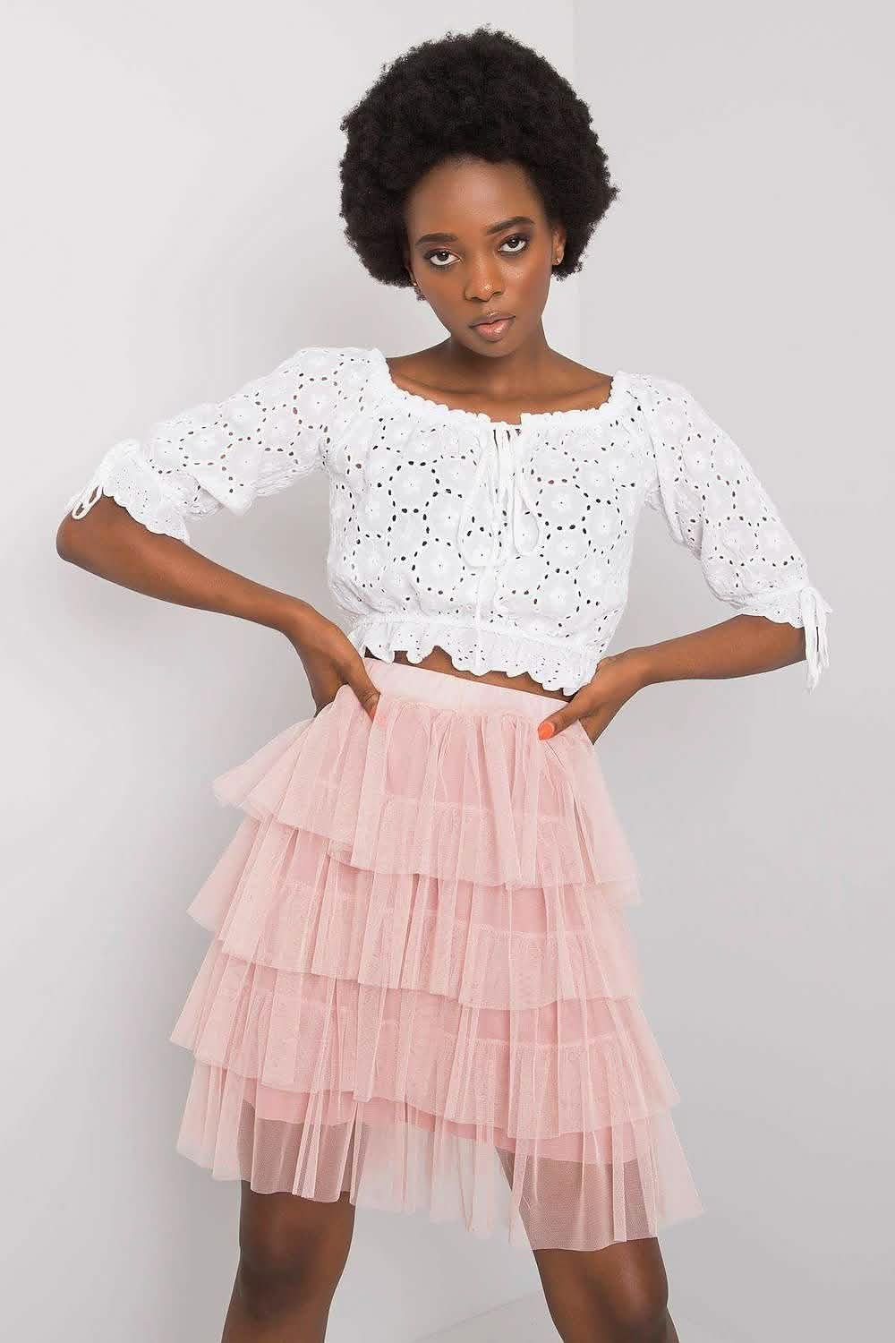 Feminine outfit featuring a white eyelet crop top paired with a pink tiered tulle skirt.