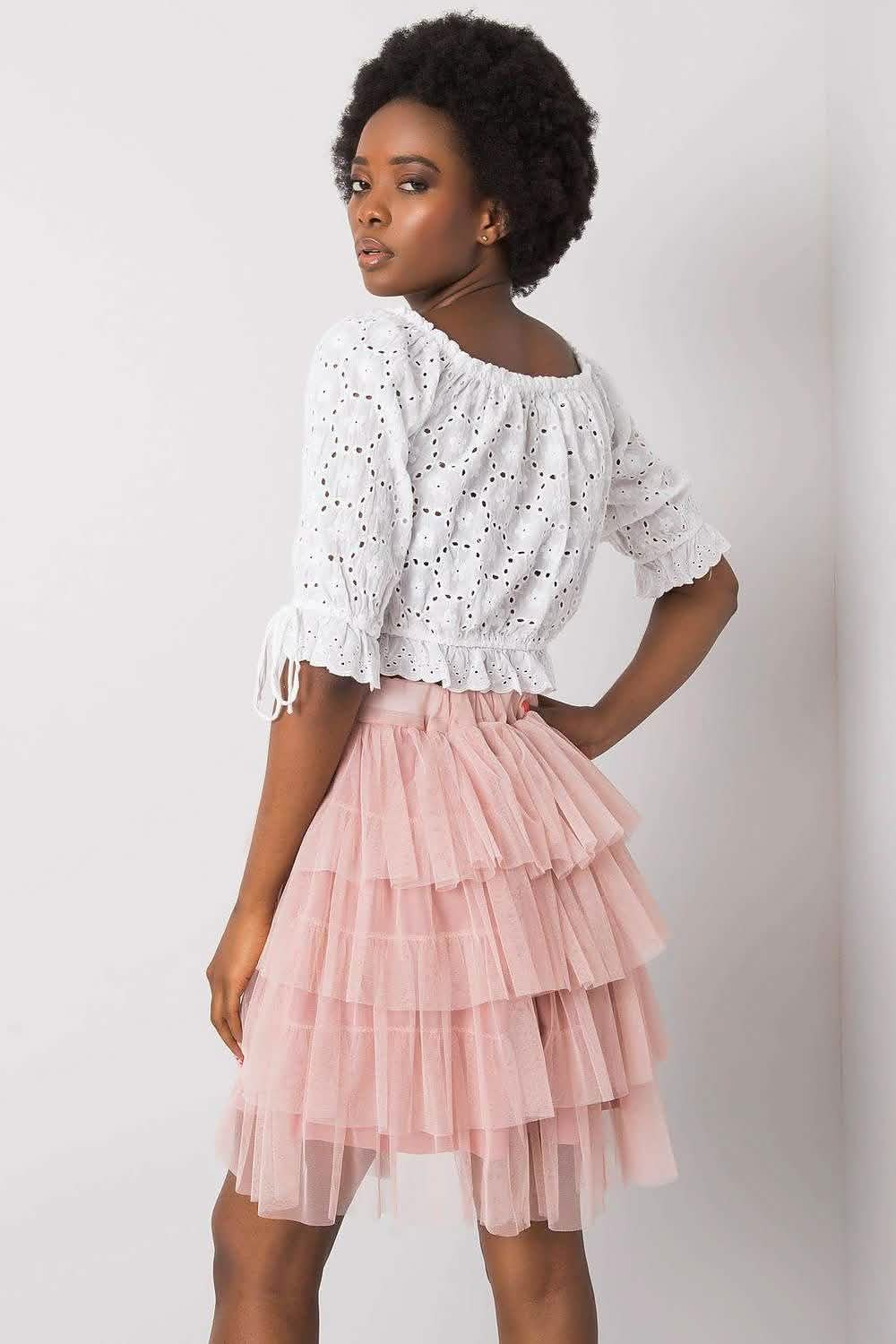 Pink tiered tulle skirt paired with a white eyelet blouse.