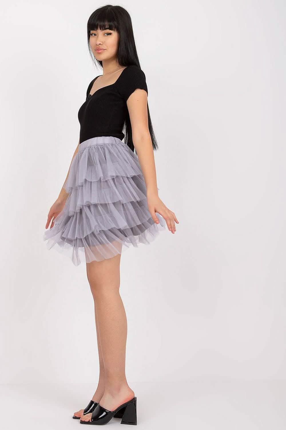 Ruffled tulle skirt in grey paired with a black sleeveless top.