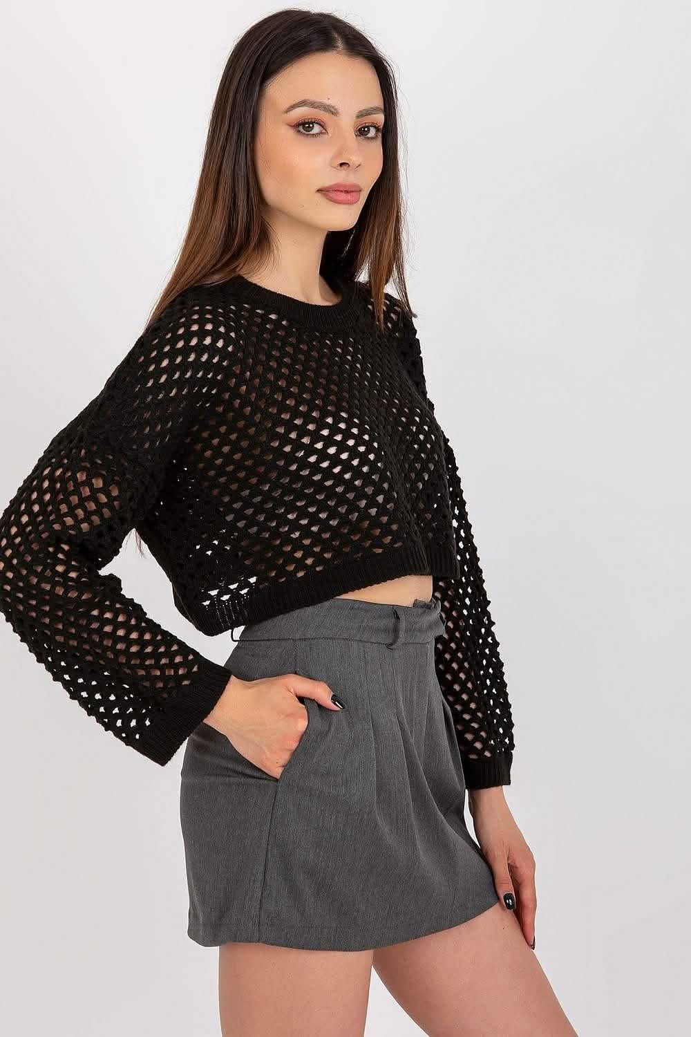 Black crochet cropped sweater with wide sleeves paired with grey shorts.