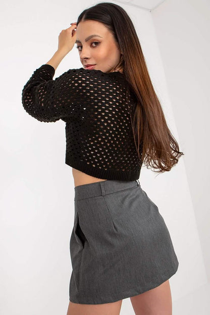 Black crochet cropped sweater paired with a gray mini skirt.