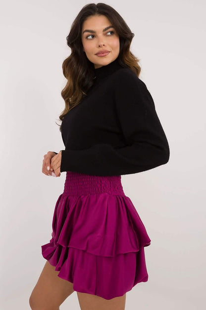 Magenta ruffled mini skirt paired with a black turtleneck sweater.