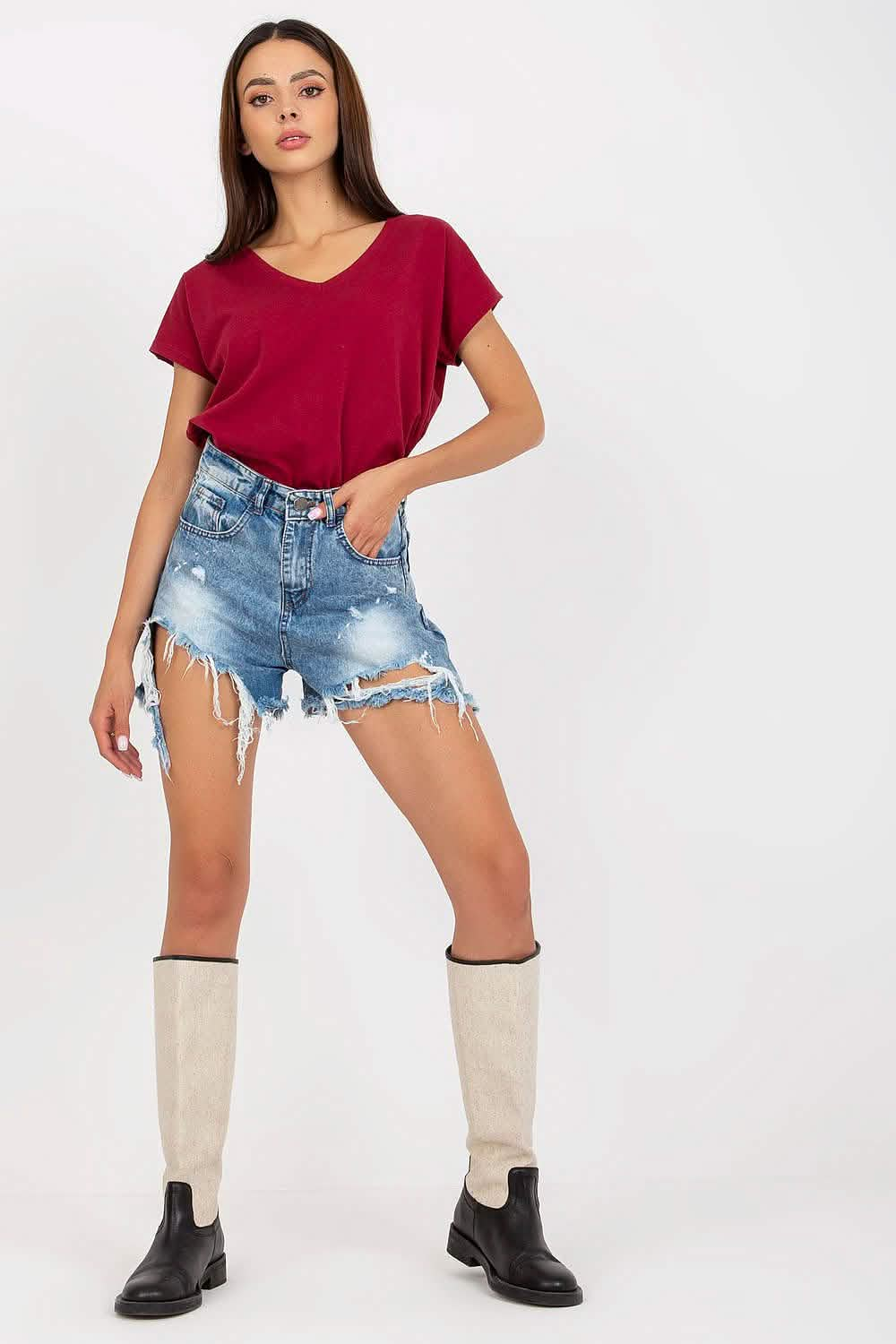 Distressed denim shorts with frayed edges paired with a burgundy v-neck t-shirt, cream knee socks, and black boots.