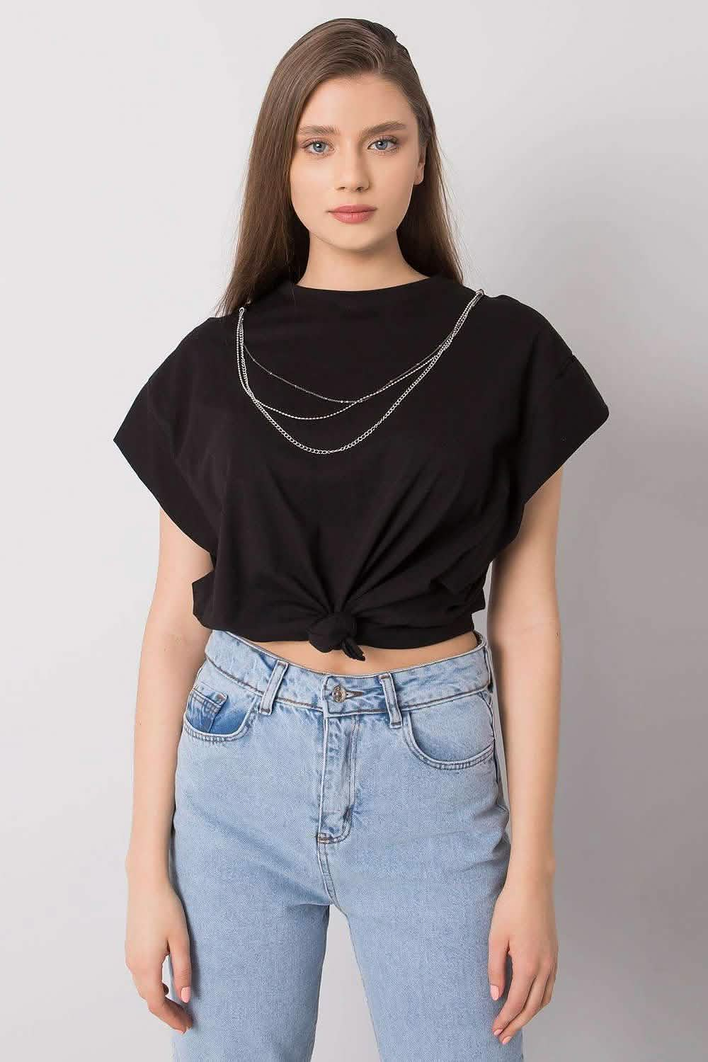 Black cropped t-shirt with a layered silver chain necklace worn with light wash jeans.