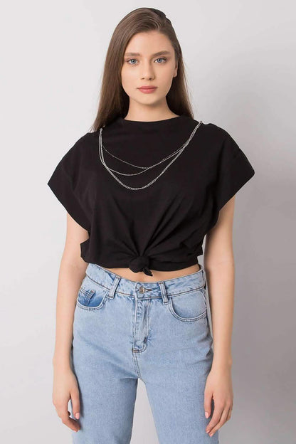 Black cropped t-shirt with a layered silver chain necklace worn with light wash jeans.