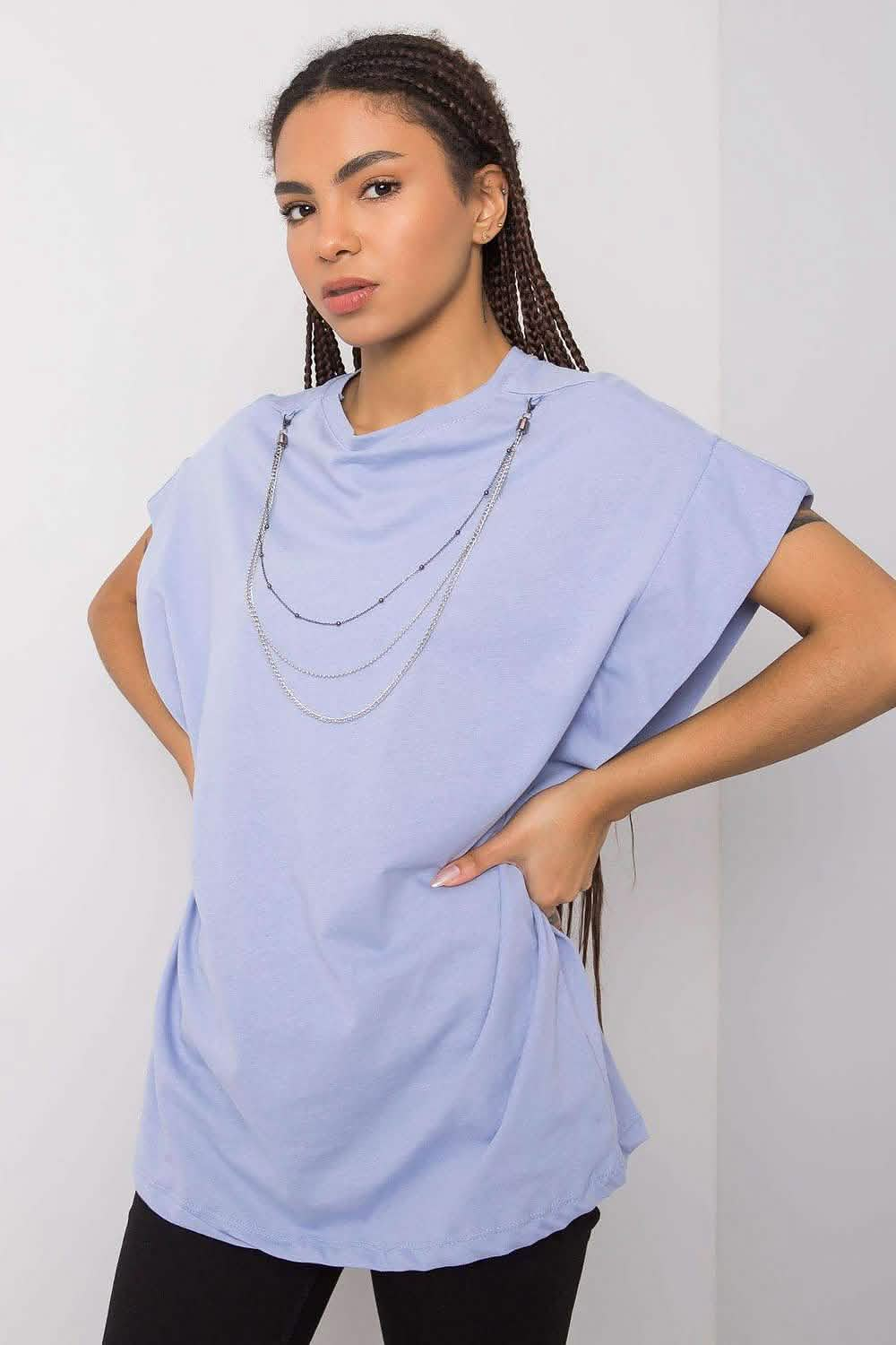 Sleeveless light blue t-shirt with a layered silver chain necklace.