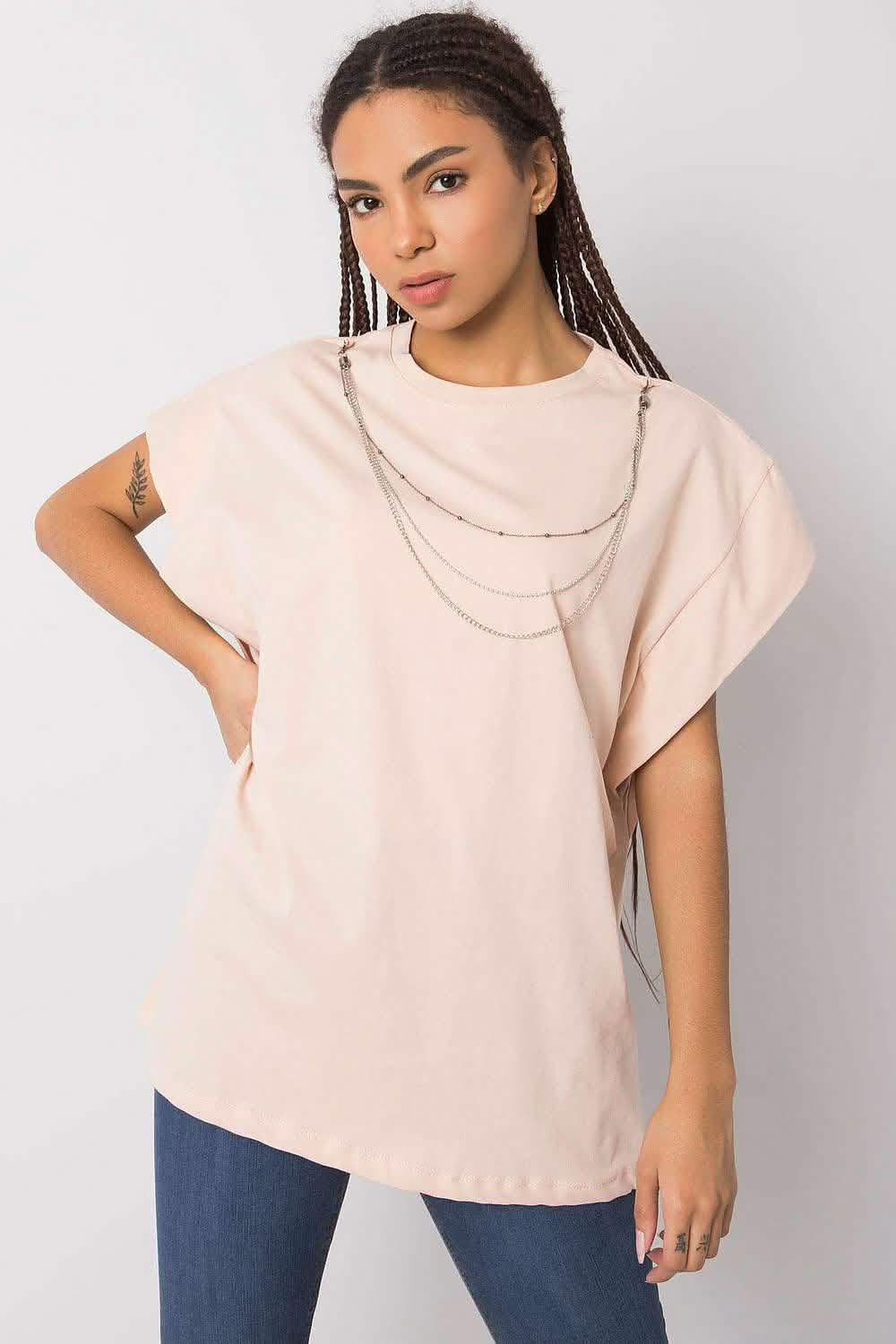 Beige oversized t-shirt with layered silver chain necklaces.