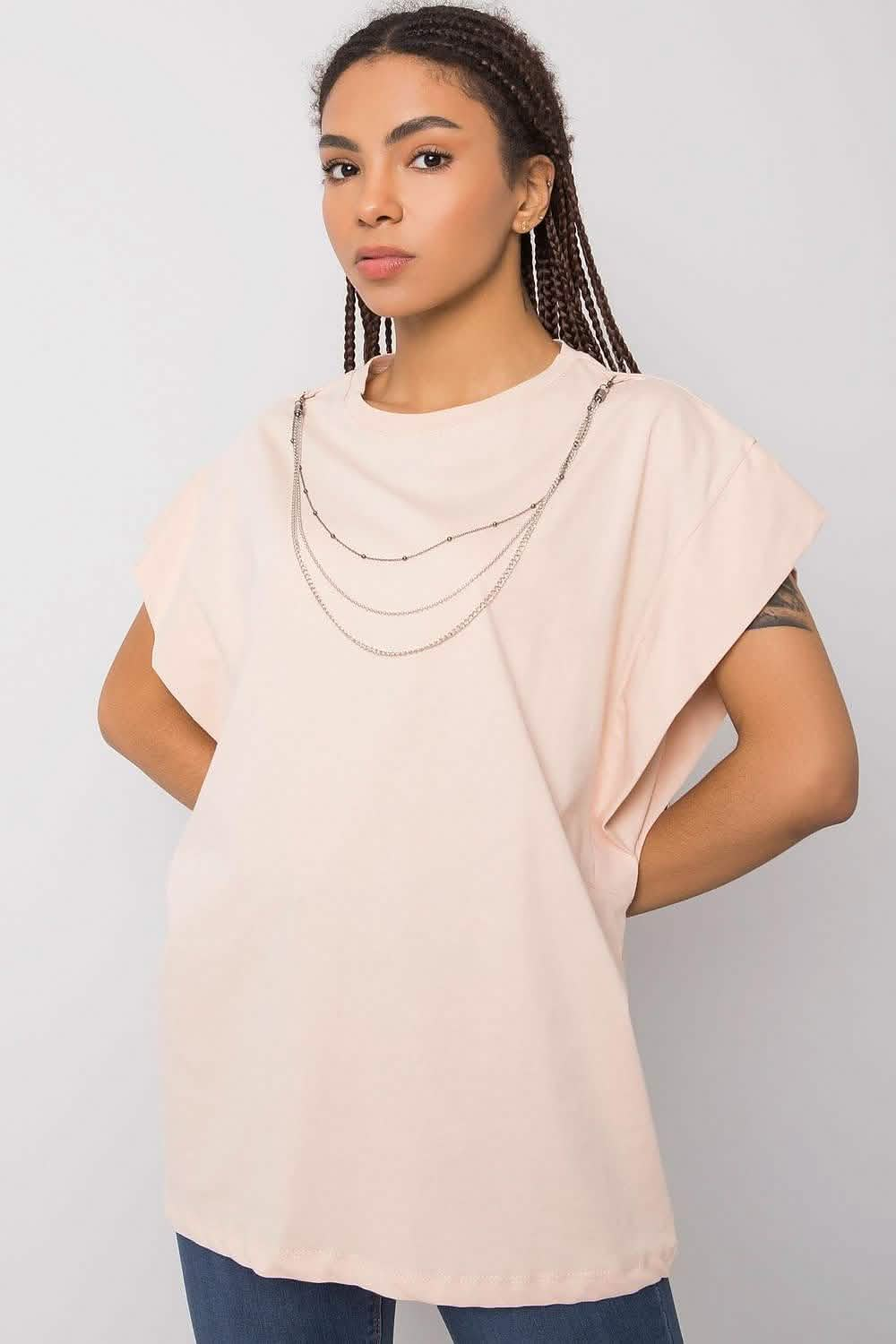 Pale pink short-sleeved top with layered silver necklaces.