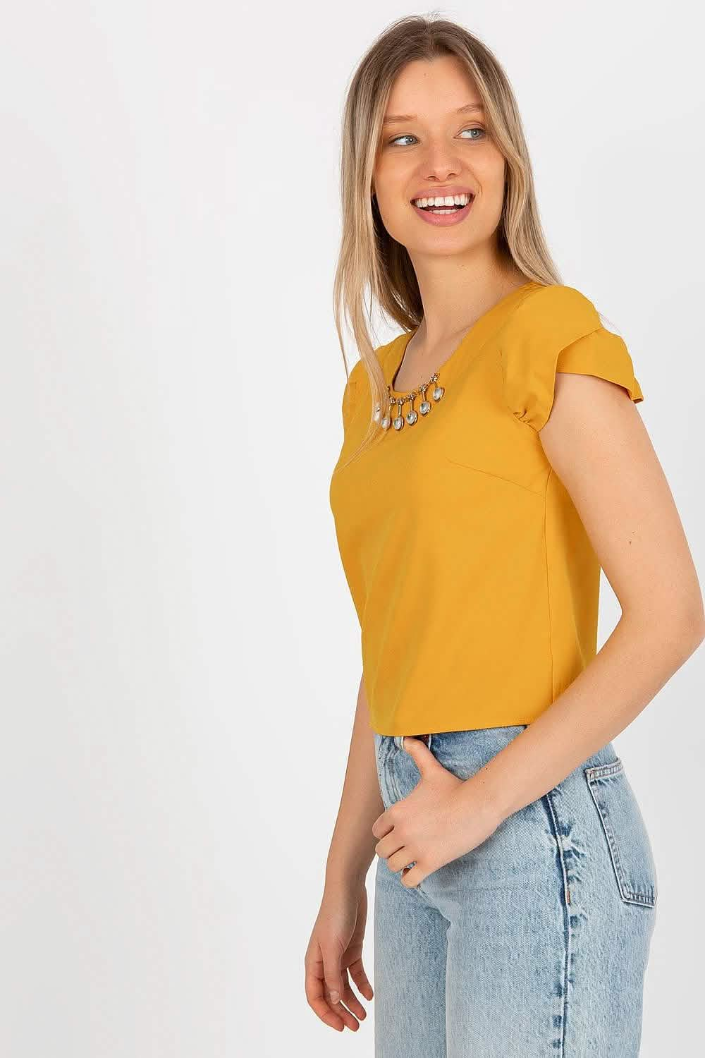 Bright mustard yellow t-shirt with cap sleeves paired with light wash jeans.