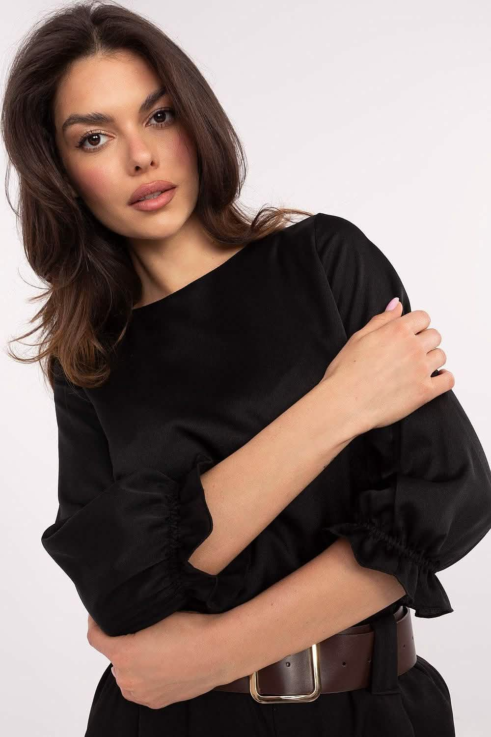 Black long-sleeved blouse with puff sleeves and a brown leather belt.