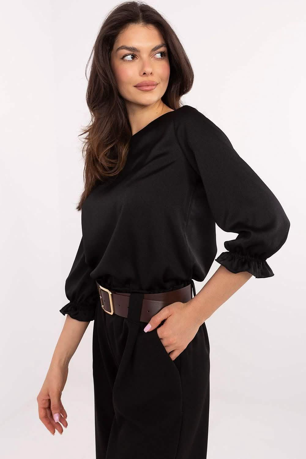 Black sweater dress with puff sleeves and a brown belt at the waist.