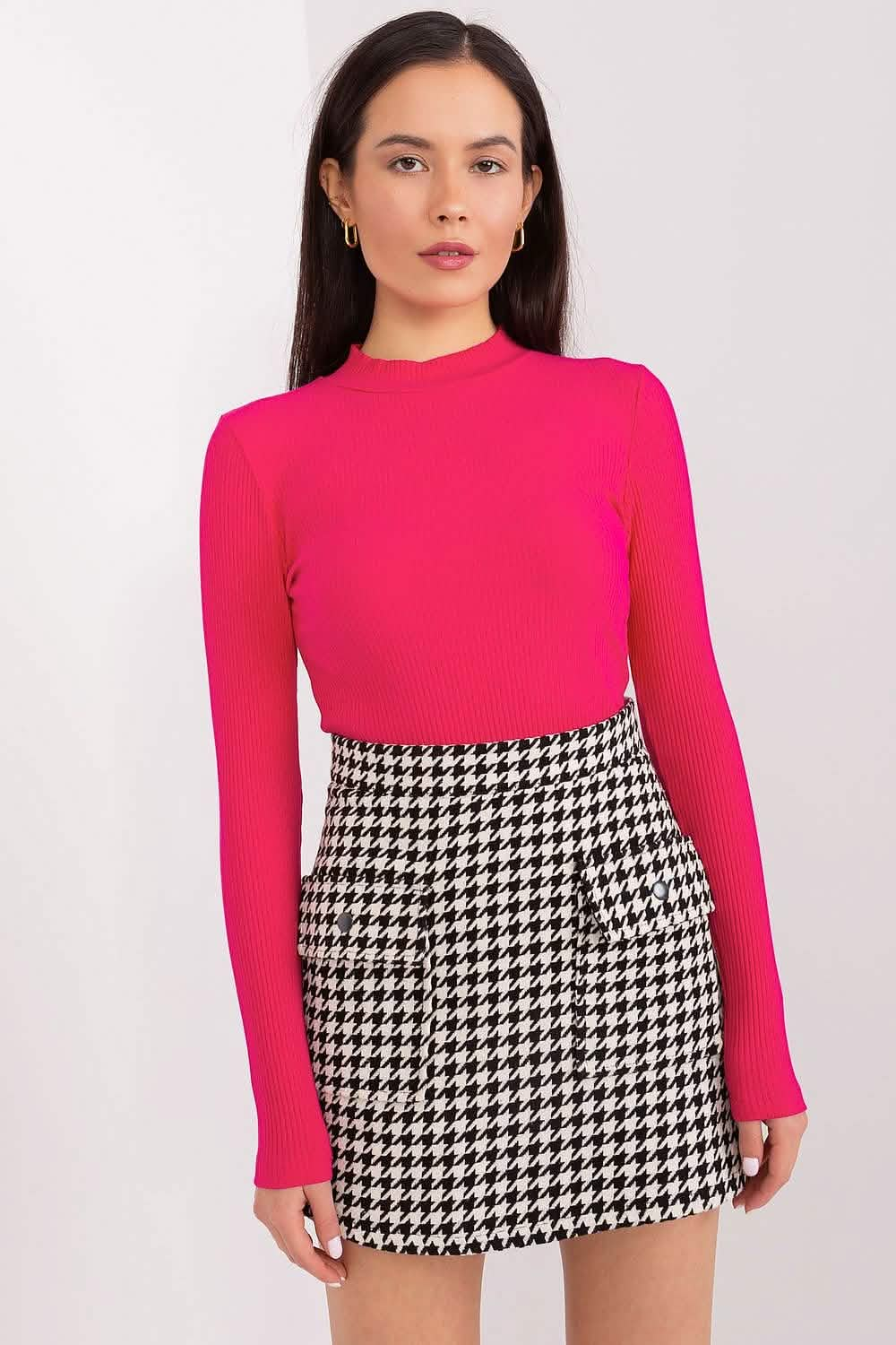 Hot pink long-sleeved top paired with a black and white houndstooth mini skirt.