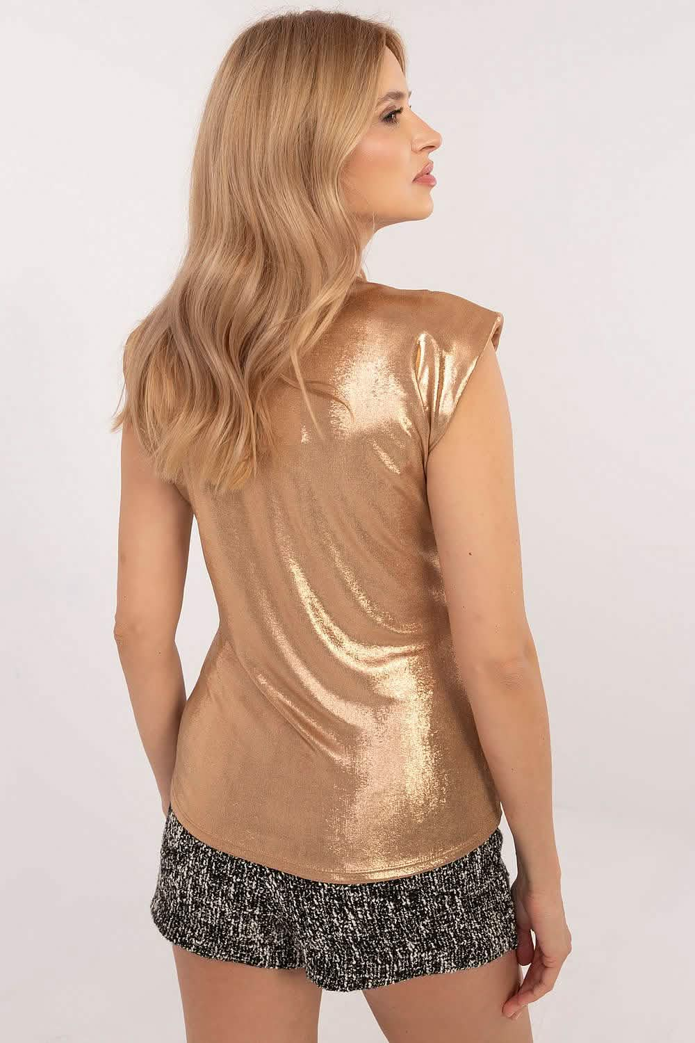 Metallic gold sleeveless top paired with sparkly silver shorts.