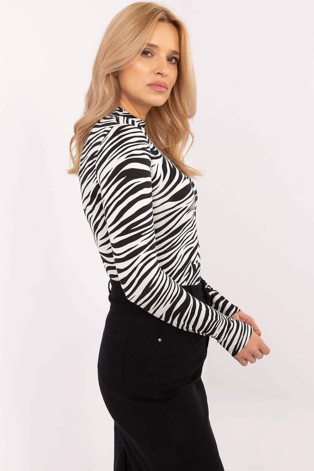 Zebra-print turtleneck top paired with a black skirt.