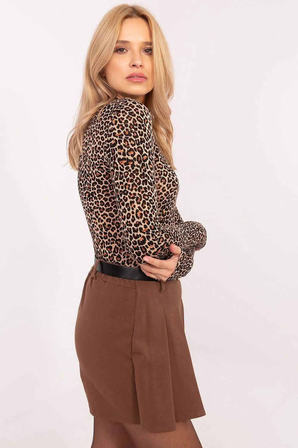 Leopard print turtleneck paired with brown skirt in a fashion pose.