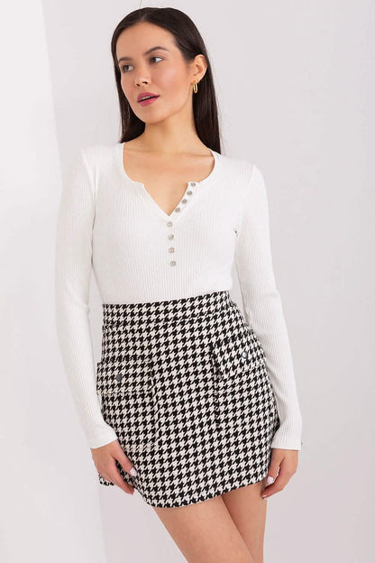 Houndstooth patterned mini skirt paired with a white henley top.