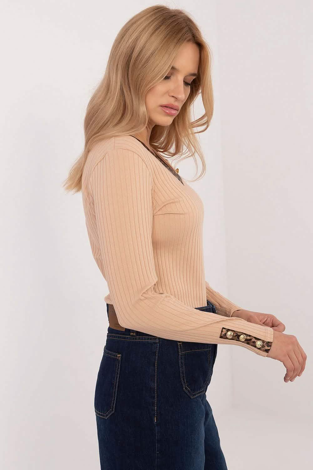 Beige ribbed long-sleeve sweater with button details at the cuffs.