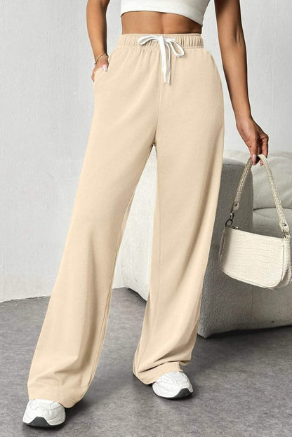 Beige wide-leg sweatpants with drawstring waist and side pockets.