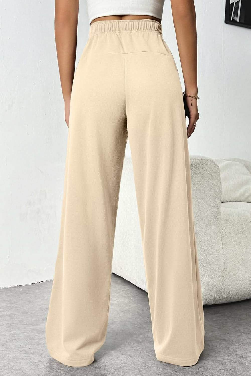 Beige wide-leg pants with an elastic waistband.