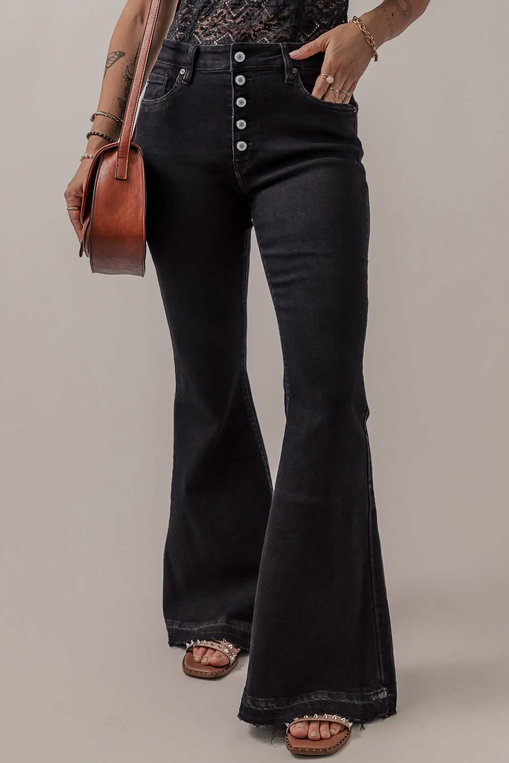 Black high-waisted flared jeans with button-fly closure and frayed hems.