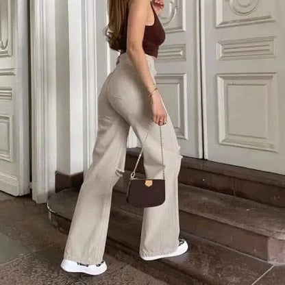 Wide-leg beige trousers paired with white sneakers.