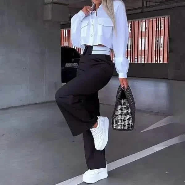 White chunky sneakers paired with black wide-leg pants and a cropped white jacket.