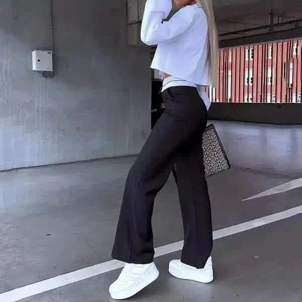 Wide-leg black dress pants paired with white sneakers and a white top.