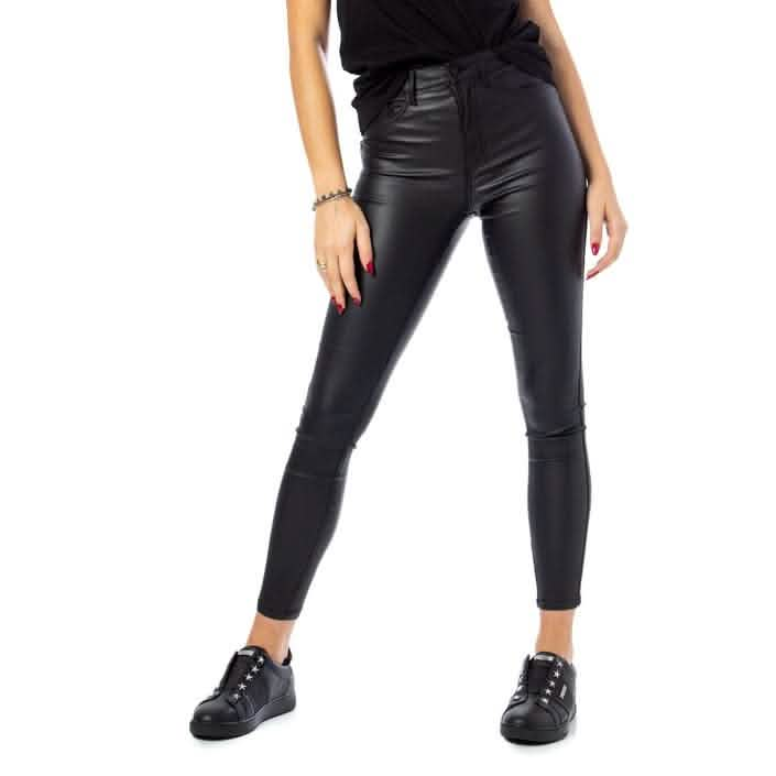 Black faux leather skinny pants paired with black sneakers.