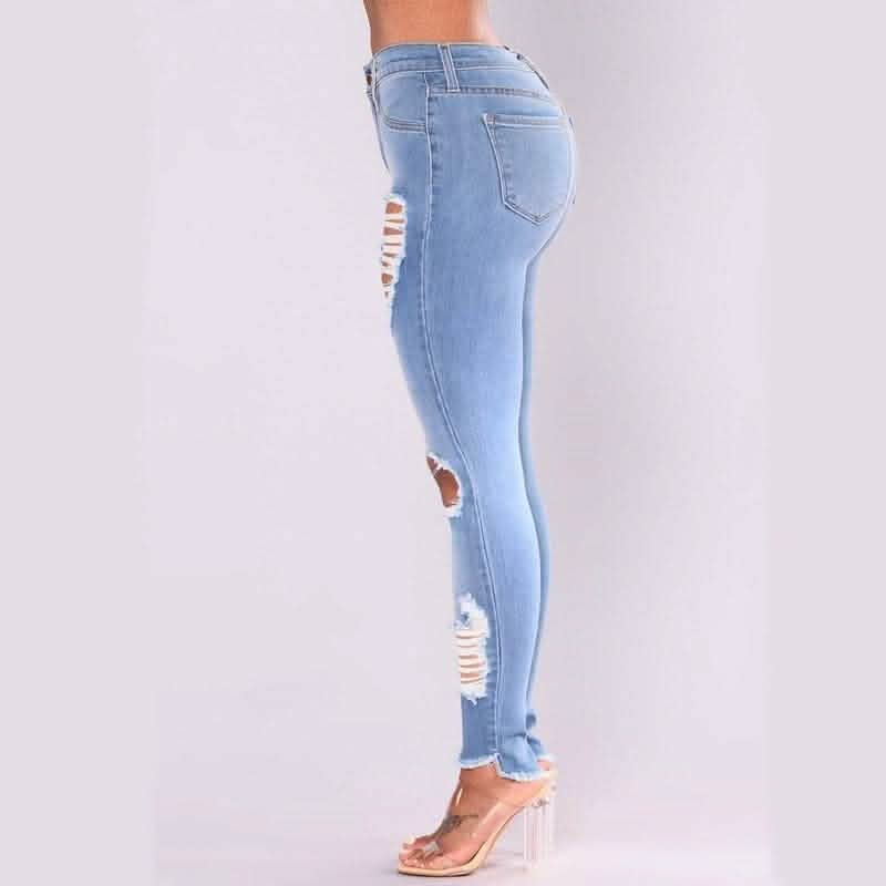 Light blue distressed skinny jeans with ripped holes along the legs.